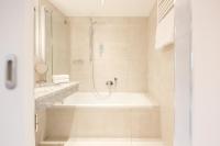 a bathroom with a bath tub and a shower at Hotel Sailer in Innsbruck