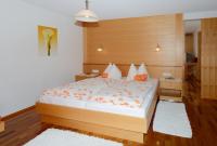 a bedroom with a large white bed with orange pillows at Fernblick Frühstückspension in Schoppernau