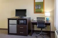 ein Zimmer mit einem Schreibtisch mit Fernseher und einem Stuhl in der Unterkunft Sleep Inn &amp; Suites Bakersfield North in Bakersfield