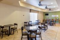 ein Restaurant mit Tischen und Stühlen in einem Raum in der Unterkunft Sleep Inn &amp; Suites Bakersfield North in Bakersfield