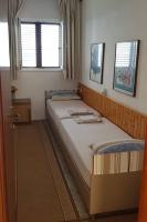 a bedroom with two twin beds and a window at Apartments by the sea Pisak, Omis - 1018 in Pisak