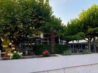un parque con árboles y flores frente a un edificio en LE ZANCHETTIN, en Mont-de-Marsan