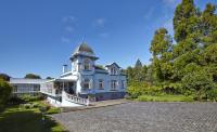 a large blue house with a clock tower on it at PortoBay Serra Golf in Santo António da Serra