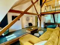 ein Wohnzimmer mit einem Sofa und einem Tisch in der Unterkunft Superbe Loft - Centre Historique De Barcelonnette in Barcelonnette