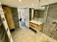 ein Bad mit einer Dusche, einem Waschbecken und einem Spiegel in der Unterkunft Superbe Loft - Centre Historique De Barcelonnette in Barcelonnette