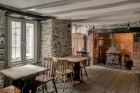 a room with a table and chairs and a fireplace at The Olde Malthouse Inn in Tintagel