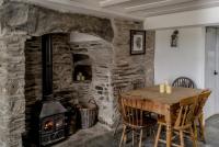 a dining room with a wood stove and a table at The Olde Malthouse Inn in Tintagel