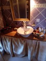 a bathroom with a sink and a mirror on a counter at Comfortable Quiet House in the countryside Porte-du-Quercy for 8 people in Sérignac