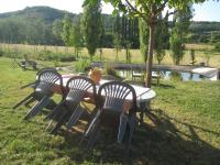 three chairs and a table in the grass at Comfortable Quiet House in the countryside Porte-du-Quercy for 8 people in Sérignac
