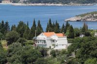 une maison blanche avec un toit orange sur une colline à côté de l&#39;eau dans l&#39;établissement Apartments by the sea Plat, Dubrovnik - 2136, à Mlini