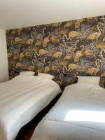 2 Betten in einem Zimmer mit einer Tapete mit Tieren in der Unterkunft Gîte Les 27 in Saint-Denis-le-Ferment