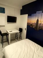 a bedroom with a bed and a desk and a tv at Lh Rooms Location in Le Havre