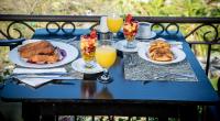 a blue table with plates of food and glasses of orange juice at Villas Sol Beach Resort in Playa Hermosa