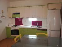 a kitchen with green cabinets and a white refrigerator at Seaside holiday house Sucuraj, Hvar - 5718 in Sućuraj