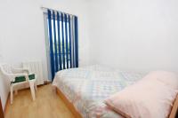 a bedroom with a bed and a chair next to a window at Apartments with a parking space Bibinje, Zadar - 5753 in Bibinje