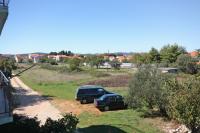 two cars parked in a field next to a road at Apartments with a parking space Bibinje, Zadar - 5753 in Bibinje