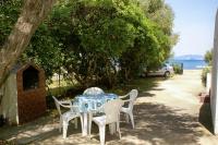 a table and chairs with a blue and white table and trees at Family Room Drace 4550a in Drače