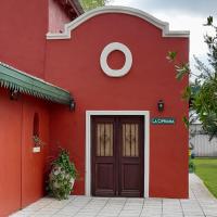 un edificio rojo con una puerta al frente en La Cipriana, en Concepción del Uruguay
