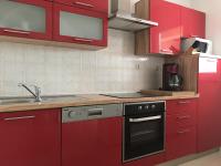a kitchen with red cabinets and a stove top oven at Apartments with a parking space Rabac, Labin - 7442 in Rabac