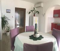 a table with purple chairs and a candle on it at Apartments with a parking space Rabac, Labin - 7442 in Rabac