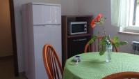 a table with a vase of flowers and a refrigerator at Apartments with a parking space Rabac, Labin - 7442 in Rabac