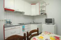 a kitchen with white cabinets and a table and a microwave at Apartments with a parking space Rabac, Labin - 7442 in Rabac