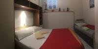 a small bedroom with a bed with a red blanket on it at Apartments with a parking space Rabac, Labin - 7442 in Rabac