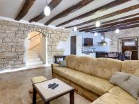 a living room with a couch and a stone wall at Holiday Home Šterna by Interhome in Brajkovići