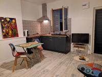 a kitchen with a table and chairs and a television at studio cosy meublé, terrasse et patio pour vélo in Rochefort
