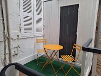 a table and two chairs sitting on a balcony at studio cosy meublé, terrasse et patio pour vélo in Rochefort