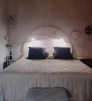 a bedroom with a large white bed with an arch at chambre d&#39;hôtes Et Puis Voilà! in Murs