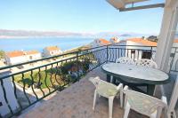 a balcony with a table and chairs and a view of the ocean at Apartments by the sea Slatine, Ciovo - 9433 in Trogir