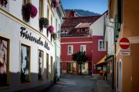 a narrow street in a town with red and white buildings at Studio Loft Murau - im Herzen der Altstadt in Murau