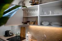 a kitchen with white cabinets and glasses on shelves at Studio Loft Murau - im Herzen der Altstadt in Murau