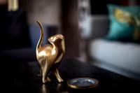 a gold statue of a dog on a table next to a coin at Studio Loft Murau - im Herzen der Altstadt in Murau