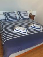 a bed with blue and white sheets and towels on it at Maison typique bretonne a 5 min de la plage a pied in Crozon