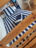 a bed with blue and white striped sheets on it at Maison typique bretonne a 5 min de la plage a pied in Crozon
