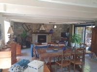 a living room with a table and chairs and a fireplace at Maison typique bretonne a 5 min de la plage a pied in Crozon