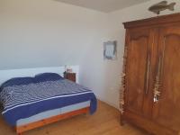 a bedroom with a bed and a wooden cabinet at Maison typique bretonne a 5 min de la plage a pied in Crozon