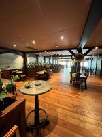 a dining room with a table and some tables and chairs at Wellness Chalet Veluwemeer in Biddinghuizen