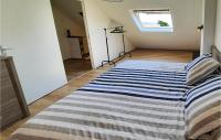 a bedroom with a bed with a striped blanket at 2 Bedroom Lovely Home In Plogoff in Plogoff