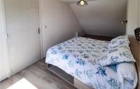 a small bedroom with a bed with blue and white sheets at 2 Bedroom Lovely Home In Plogoff in Plogoff