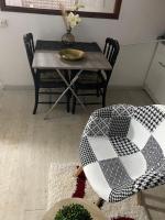 a dining room table and chairs with a black and white quilt at Pois doux in Fort-de-France