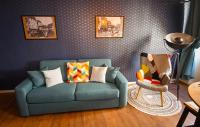 a living room with a blue couch and a lamp at Au Fil du Temps in Sélestat