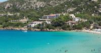 Un grupo de personas en una playa en el agua. en Hotel La Bisaccia, en Baja Sardinia