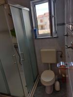 a bathroom with a toilet and a shower and a window at Apartment Nenadic in Hrahorić