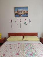 a bedroom with a bed with flowers and butterflies on the wall at Apartment Nenadic in Hrahorić