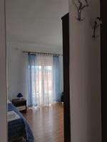 a room with a bed and a window with blue curtains at Apartment Nenadic in Hrahorić