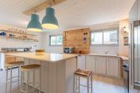 a kitchen with a counter and stools in it at Maison Mimizan plage in Mimizan