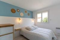 a white bedroom with a bed and a window at Maison Mimizan plage in Mimizan